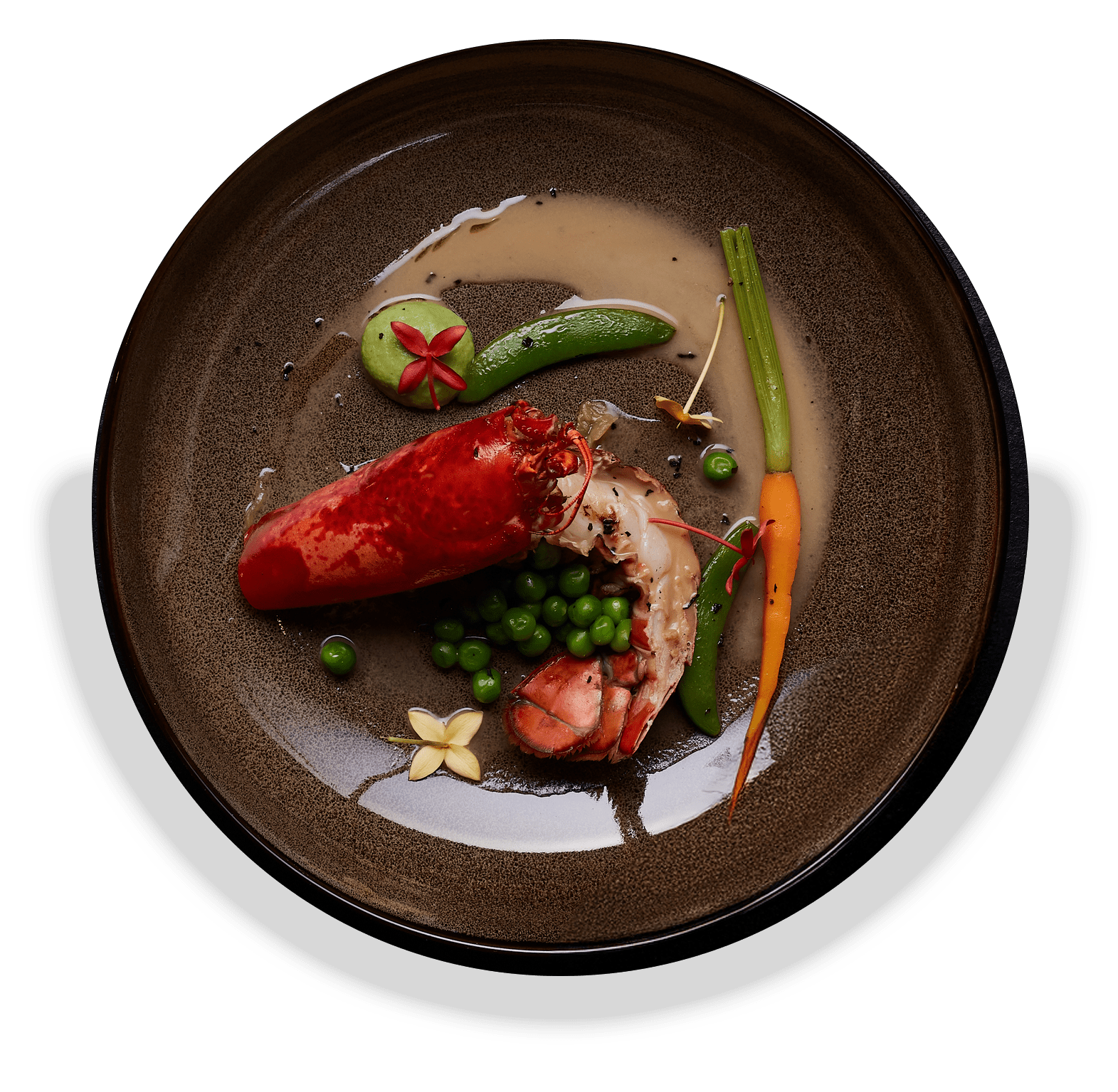 A gourmet plate featuring a succulent lobster alongside fresh peas and vibrant carrots, elegantly arranged for presentation.