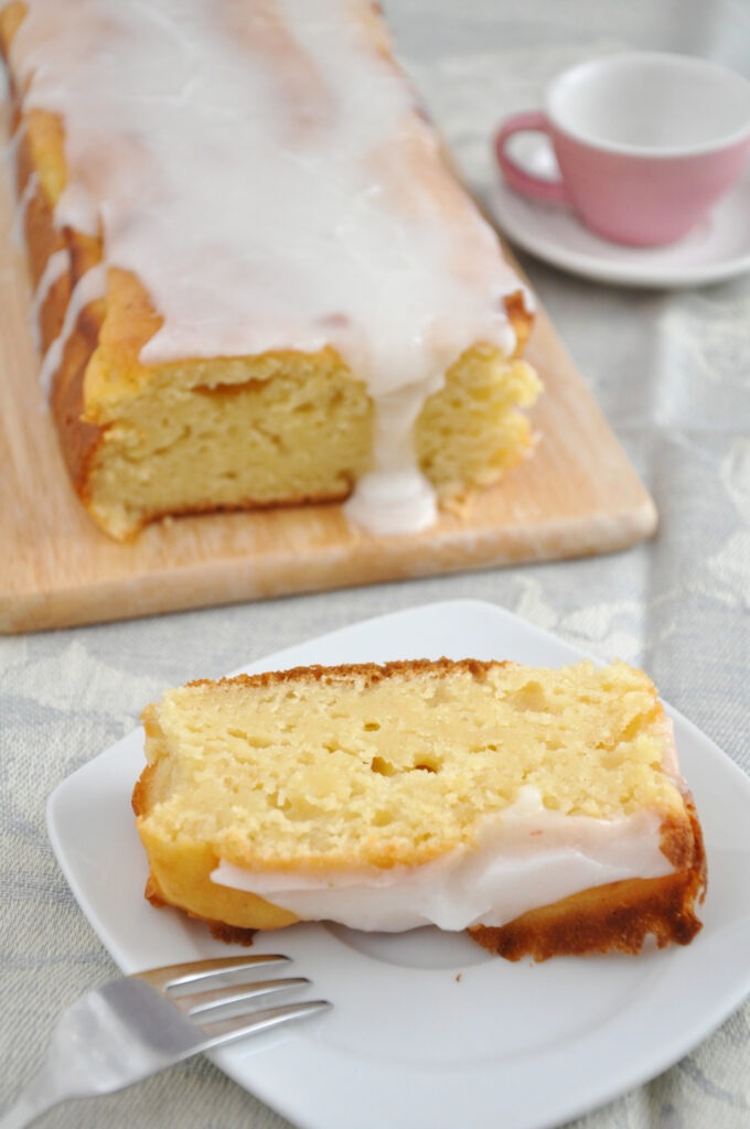 Lemon Cake on the plate with a cup on the side.